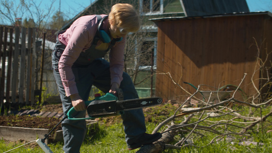 成年妇女用电锯砍树视频