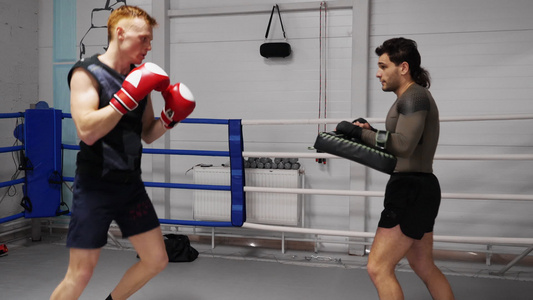 拳击手正在练习踢球用运动垫在战斗俱乐部的训练视频
