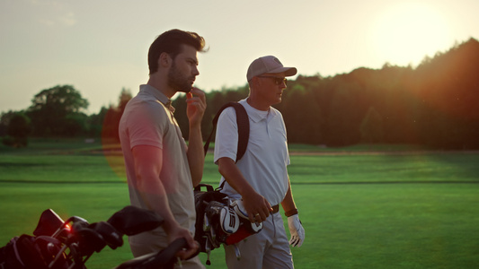有钱人在日落夏季球场打高尔夫球视频