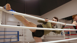 年轻运动运动员在拳击俱乐部的圈子上伸展双腿10秒视频
