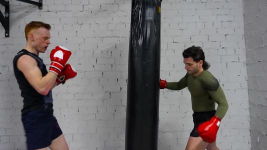 拳击手套的战斗机男子在个人训练时对战斗袋进行打击健身视频