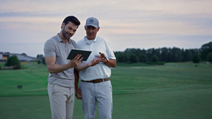 两名高尔夫球手在田野上搜索平板电脑19秒视频