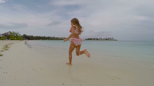 快乐的小女孩在暑假期间在沙滩上玩得开心视频