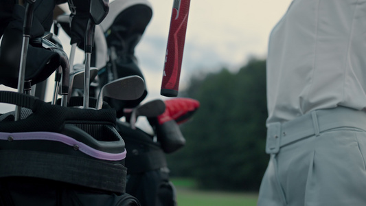 女人手拿着俱乐部高尔夫设备在球场上视频