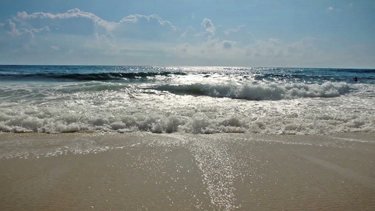 海浪在沙沙沙滩阳光和阴云的天空上视频