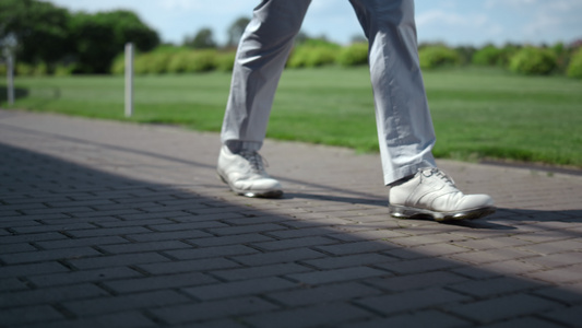 高尔夫球手的腿在球场上行走视频