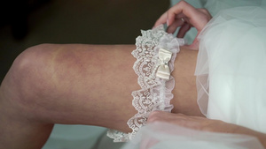 年轻新娘在她的腿上穿上婚礼装饰13秒视频