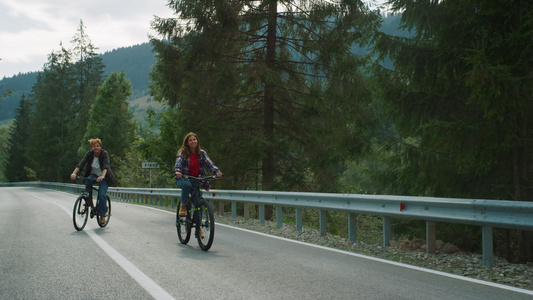 夫妇在森林景观中一起骑自行车山路视频