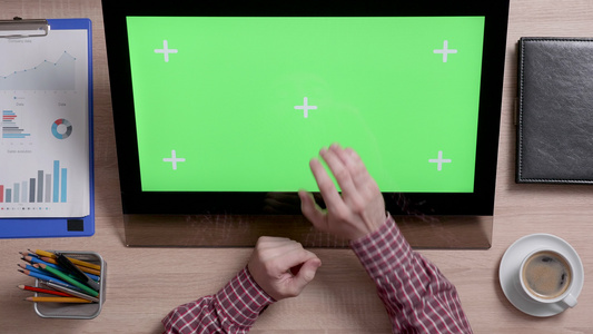 男子手的顶部视图触摸显示器上的绿色屏幕中心视频