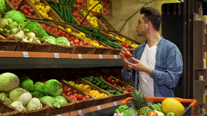男人从超市的架子上拿番茄和黄瓜23秒视频