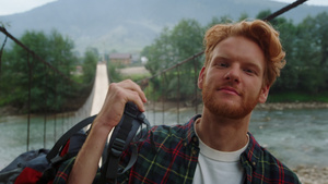 微笑的徒步旅行者在河桥肖像上拍照23秒视频