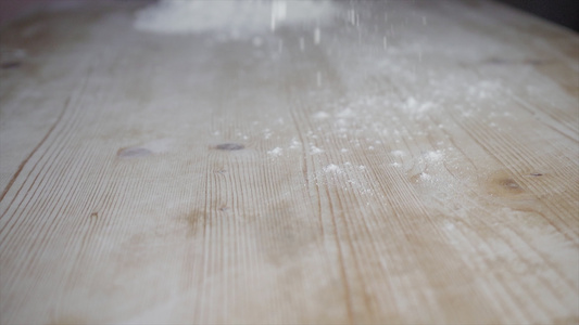 白面粉倒在浅木制面团桌上慢慢地运动关闭视频