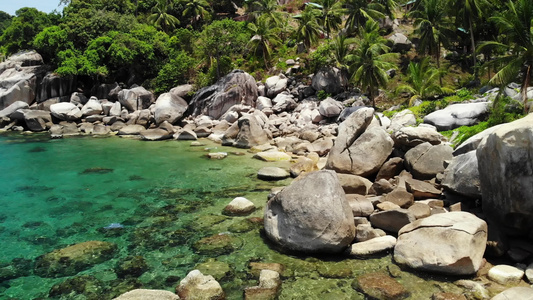 热带棕榈树和小海滩上的石头在泰国阳光明媚的日子里在视频