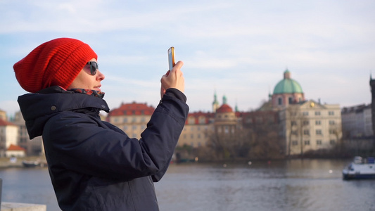 穿着红帽的年轻美女在Prague捷克旅游用智能手机视频