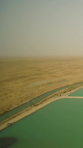 新疆和田塔克拉玛干沙漠里的水库航拍沙漠水库视频