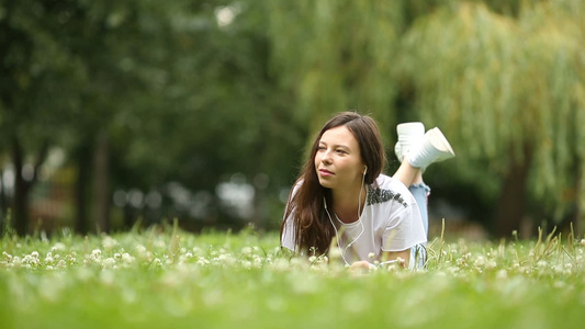 可爱女人坐在公园里时正在看手机短信的短信笑声视频