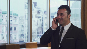 一个快乐的男人在办公室里在他的手机上说话18秒视频