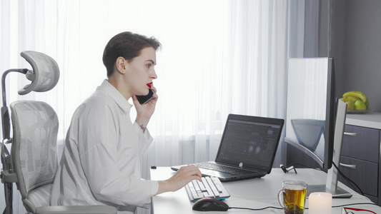 从事两台电脑工作时在电话上说话的女企业主视频