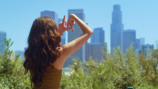 未知的女孩手指在城市景观视图上做标志LA视频