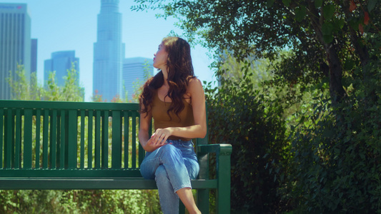 女士坐在长椅上欣赏摩天大楼的景色视频