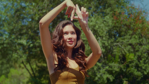 女人在公园里用手指展示LA标志10秒视频