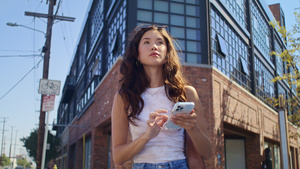 年轻女子使用智能手机站在十字路口9秒视频