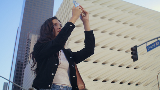 女游客在智能手机上制作照片街视频