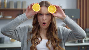 情感女孩在厨房用橙子做面孔17秒视频