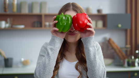 年轻女性在厨房用多彩胡椒改变情感的肖像视频