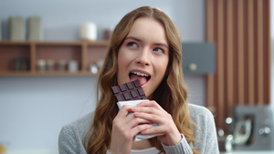 美丽的女孩在室内尝巧克力的味道18秒视频