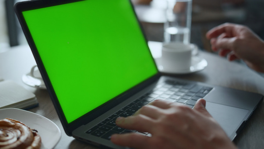 男人的手在咖啡馆餐厅的桌子上打字键盘笔记本电脑绿屏视频