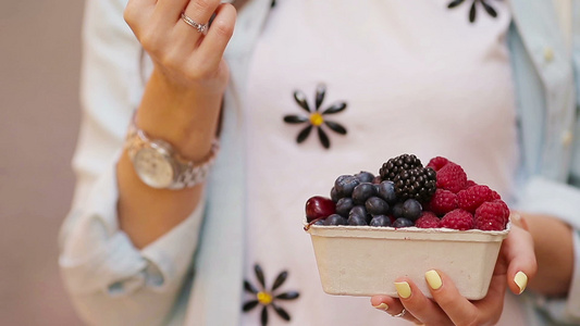 女性手中的特写浆果果实市场上的蓝莓覆盆子草莓樱桃和视频