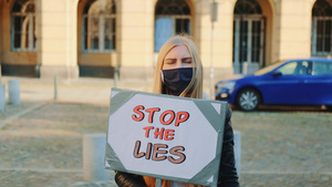 身戴抗争横幅的蒙面妇女呼吁停止谎言20秒视频