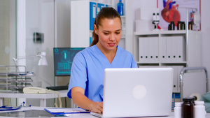 护士在剪贴板上记笔记阅读膝上型电脑的医疗饶舌之后14秒视频