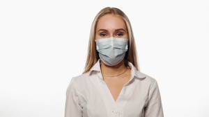 以医疗面具点头的年轻护士作为协议看镜头在白色背景上7秒视频