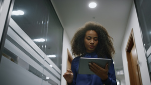 非裔美国女商务人士在办公室行走搜索公司的数字平板电脑28秒视频