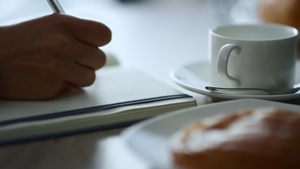女人手写记事本坐在咖啡馆工作文书工作笔记在餐厅11秒视频