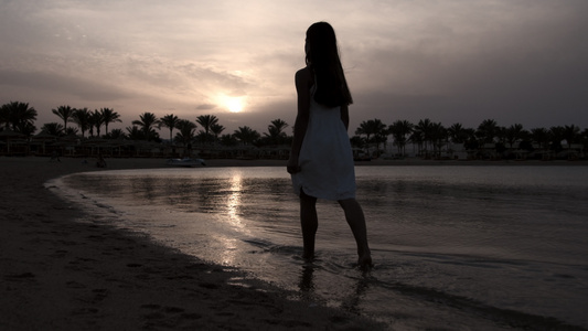 赤脚女孩在日落海滩上行走视频