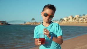 小男孩戴着墨镜在阳光明媚的海边享受暑假时光16秒视频