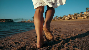 年轻小女孩在暑假时沿着沙滩海岸走路腿部特写16秒视频
