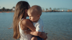 可爱的小女孩抱着弟弟在美丽的海岸享受阳光明媚的早晨23秒视频