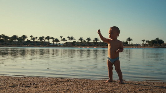 可爱的婴儿男孩在海滩玩耍视频