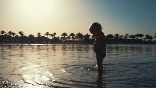 可爱的宝宝在海边的海水中玩耍视频