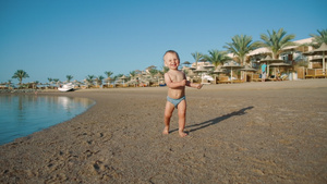 欢乐的宝宝沿着沙滩海岸玩耍22秒视频