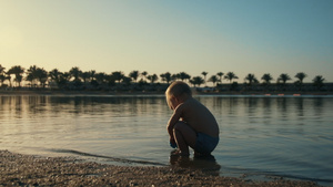 可爱的孩子在日落海岸的水里玩耍23秒视频