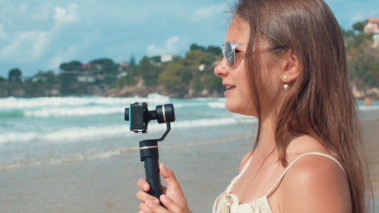 快乐的女孩在海边录制vlog视频