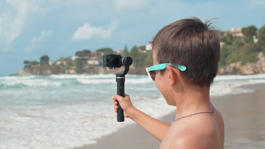 在海边拍vlog的快乐小男孩视频