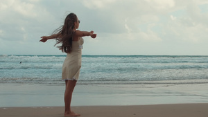 快乐的年轻女孩在海滩上放松张开双臂12秒视频