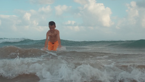 快乐的小男孩在海边玩水享受12秒视频