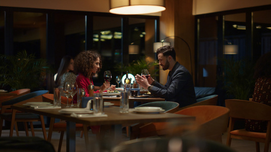 幸福的情侣在高档餐厅的餐桌上喝着酒杯视频
